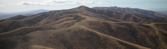 North Hansel Mountains HP as viewed from Peak 6774 to the north. The 2-mile connecting ridge has an old 2-track road covering most of it. Livingston Douglas Photo