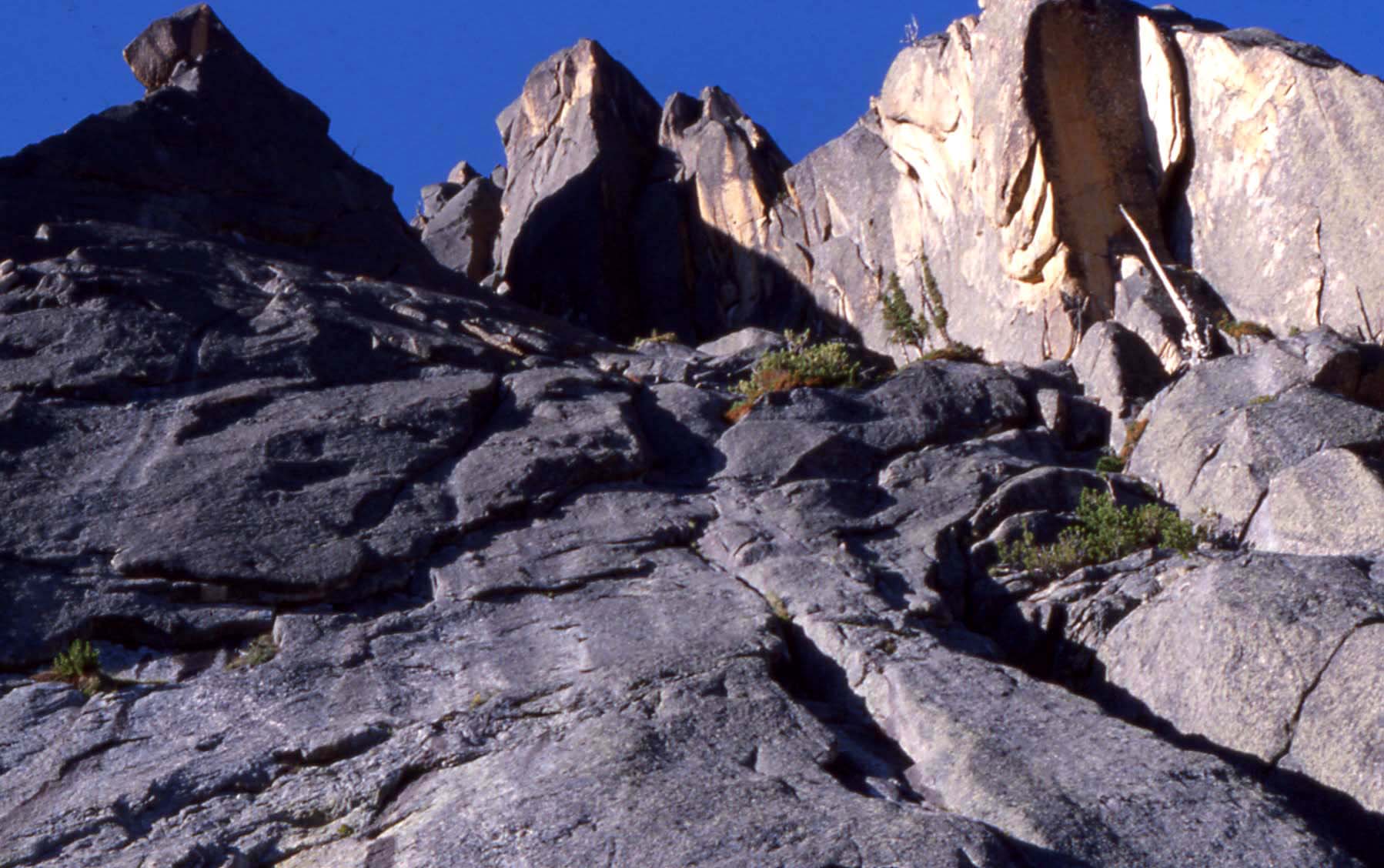 North Face Bypass route, Big Baron Spire. Follow low angle slabs up into the steep area, then escape up cracks to right.