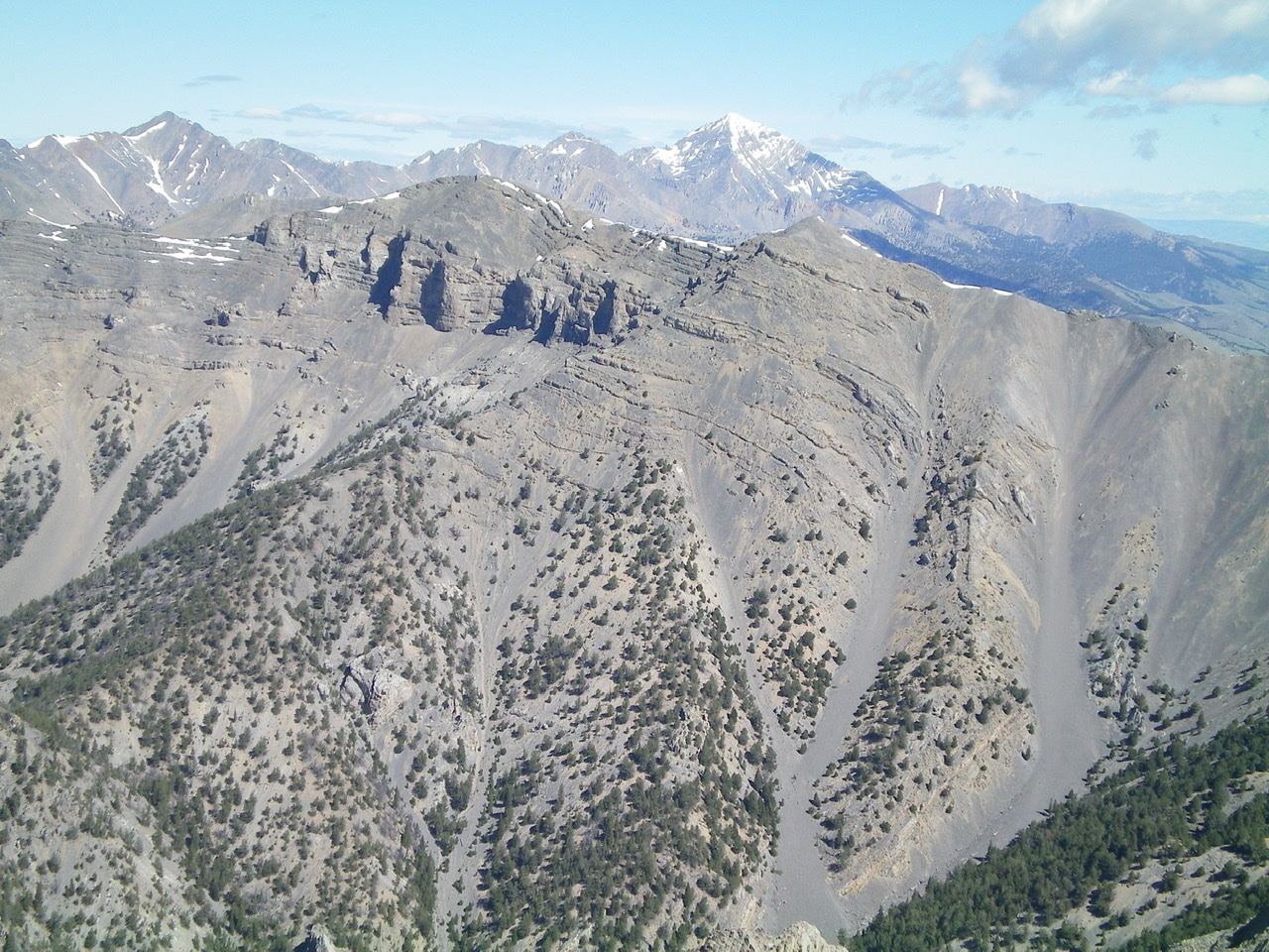 Shril Benchmark (left of center) and Point 10601 (right of center) and the magnificent South Ridge (descending diagonally leftward) with snow-capped Diamond Peak in the distance. Livingston Douglas Photo