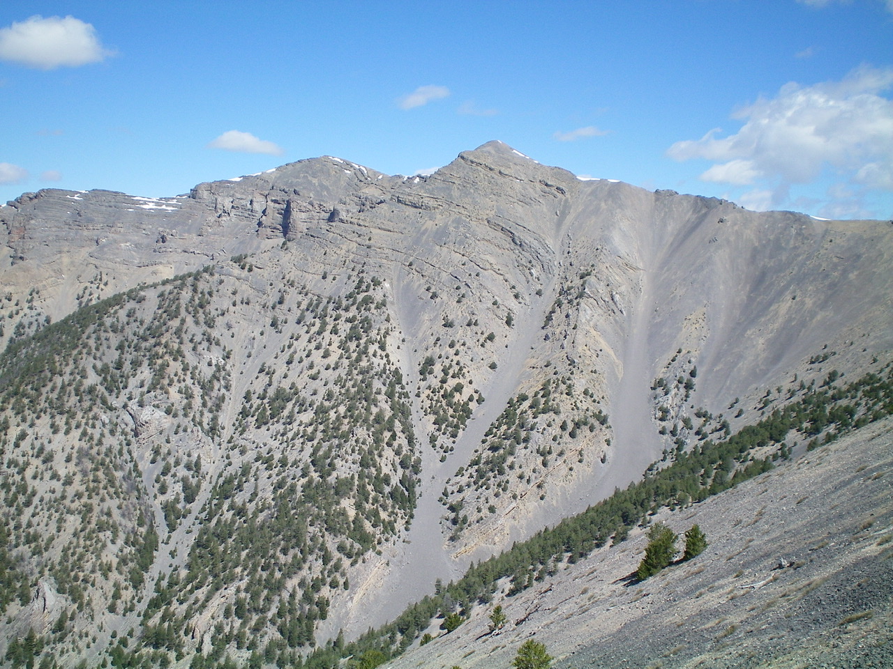Point 10601 (slightly right of center), the South Ridge (descending leftward), and the crumbly scree/gravel that must be navigated on the Southeast Face to descend the steps/breaks in the ridge. Watch your step up here! Livingston Douglas Photo