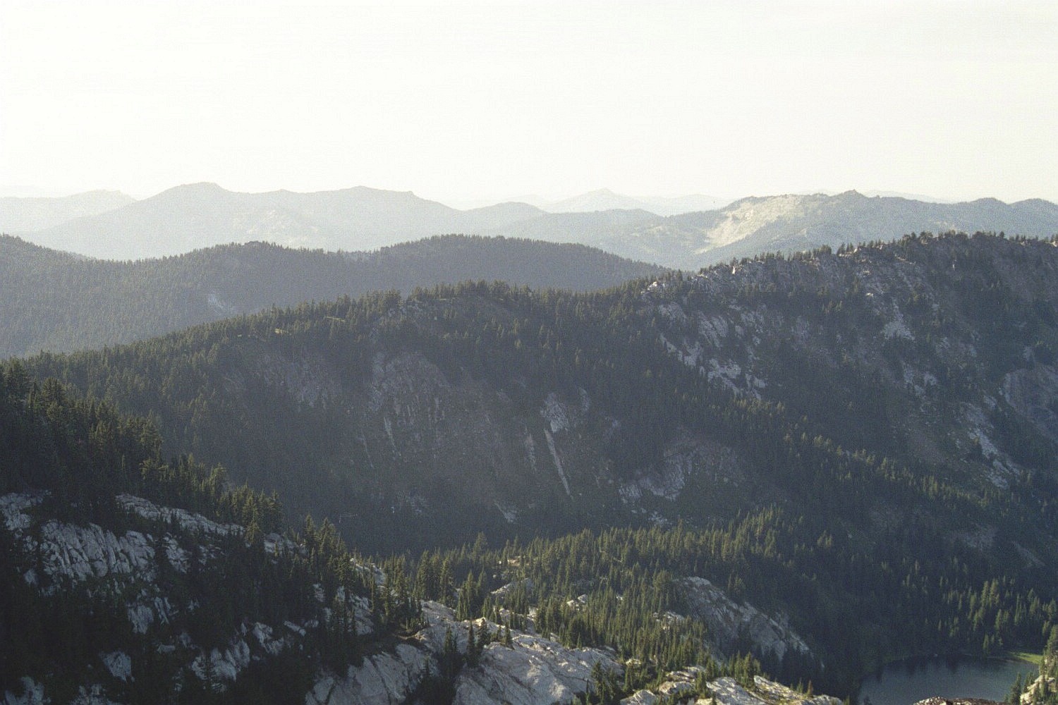 Looking northwest across Avalanch Ridge. The rounded summit on the left is Heart Peak, the one with a rock face at right center is Mallard Peak and the pyramid barely visible near the center is Snow Peak. Cliff Lake is at lower right. August 2006 Mike Hays Photo