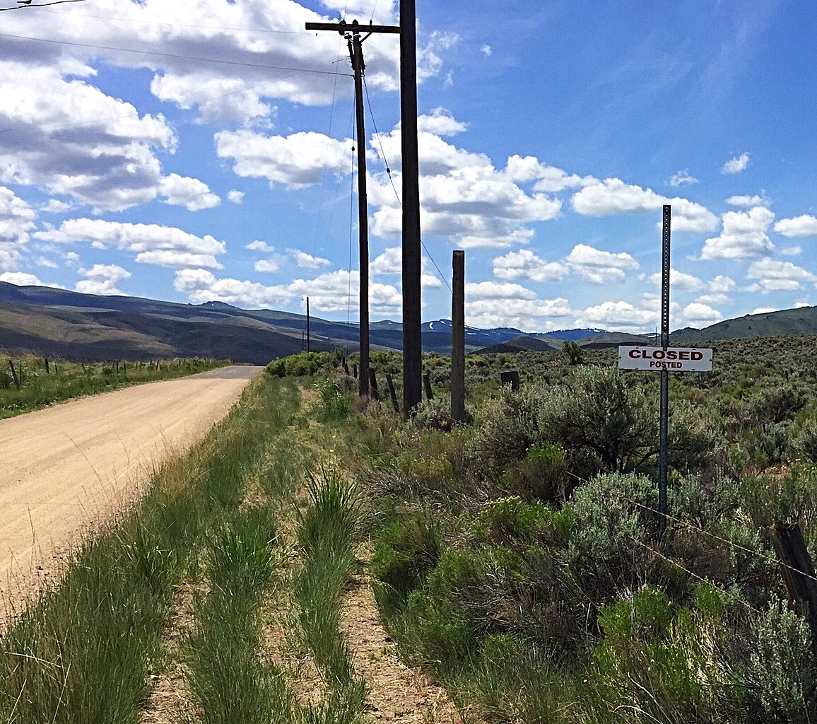 This is an example of a strategically posted sign. The land to the right of the sign is private. The road is public. However, the sign's placement implies the road is also closed to the public.