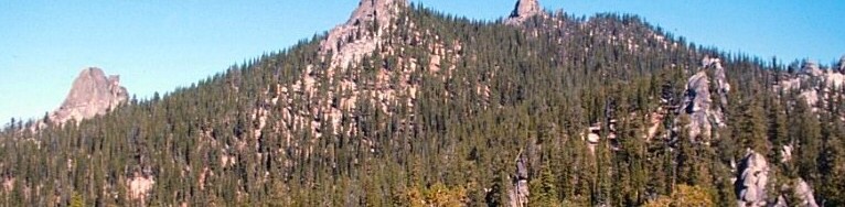 Needles Peak from the southwest. Three of the granite towers on this peak are visible in this photo. There are a large number of one and two pitch routes on these formation many of which were first climbed by Doug Colwell.